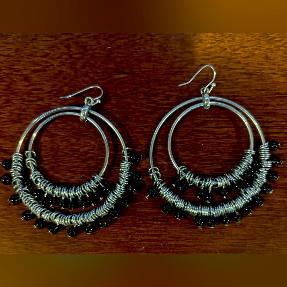 Large silvertone dangle hoop earrings with dangling black beads